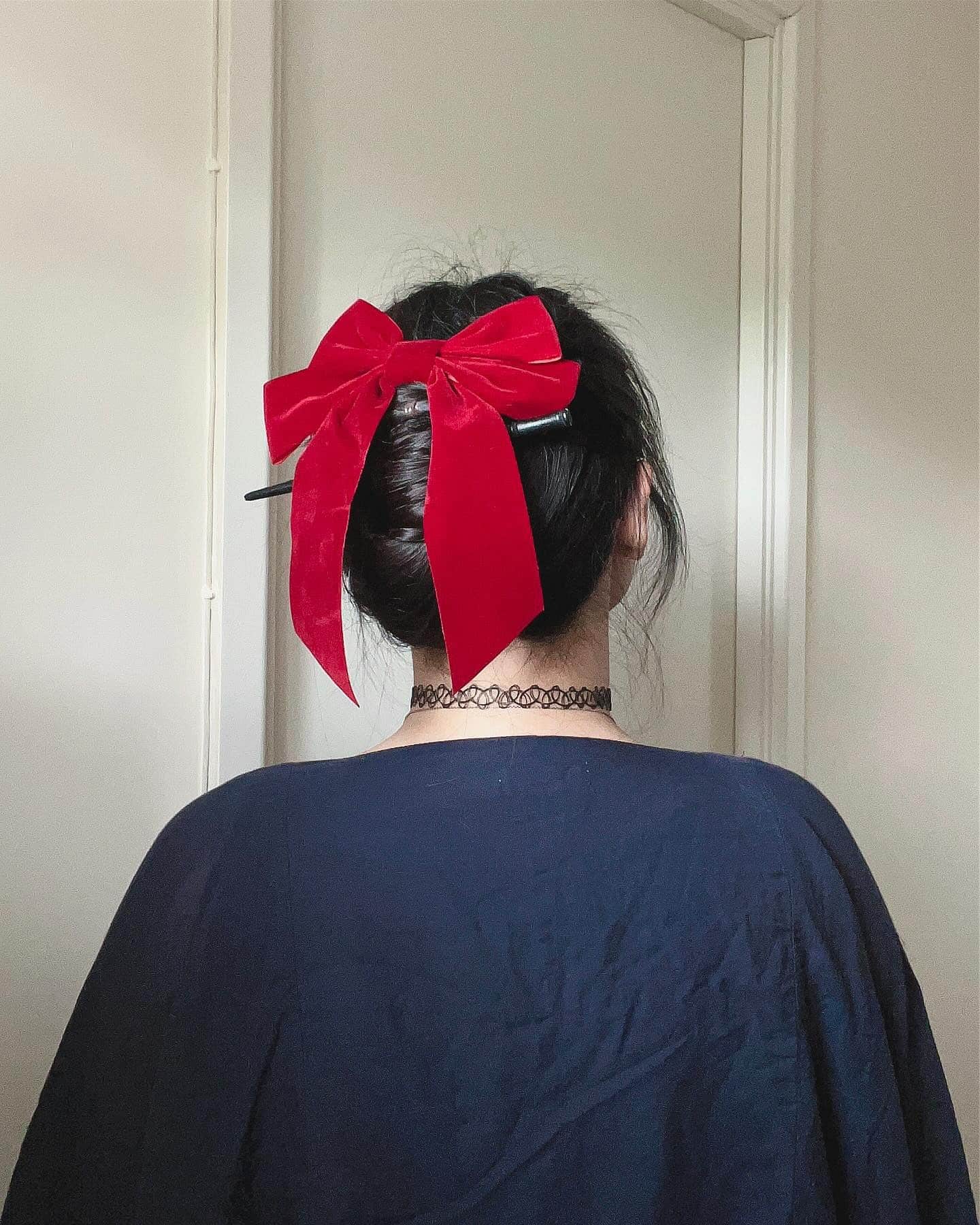 14. High Bun with Bold Red Velvet Bow on Black Hair - Cute Hairstyles