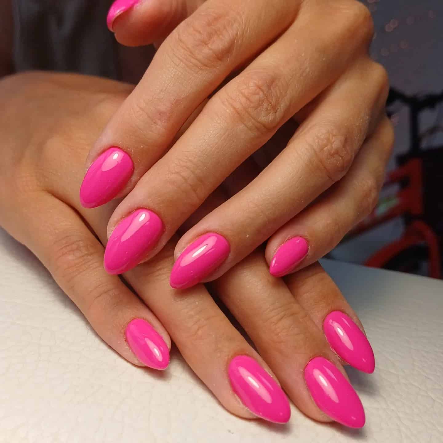 12. Glossy Neon Pink Almond Nails - neon pink nail ideas