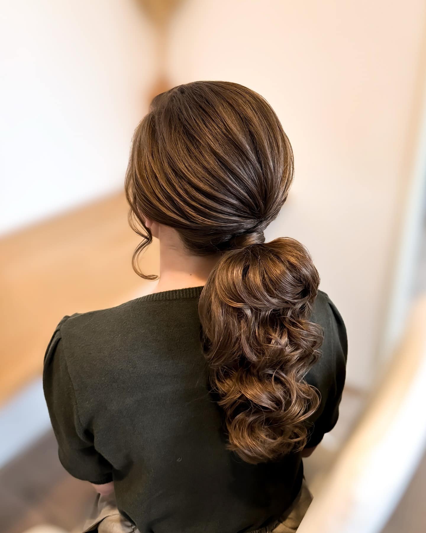 4. Sleek Brunette Low Ponytail with Glossy Waves - Wedding Hairstyles