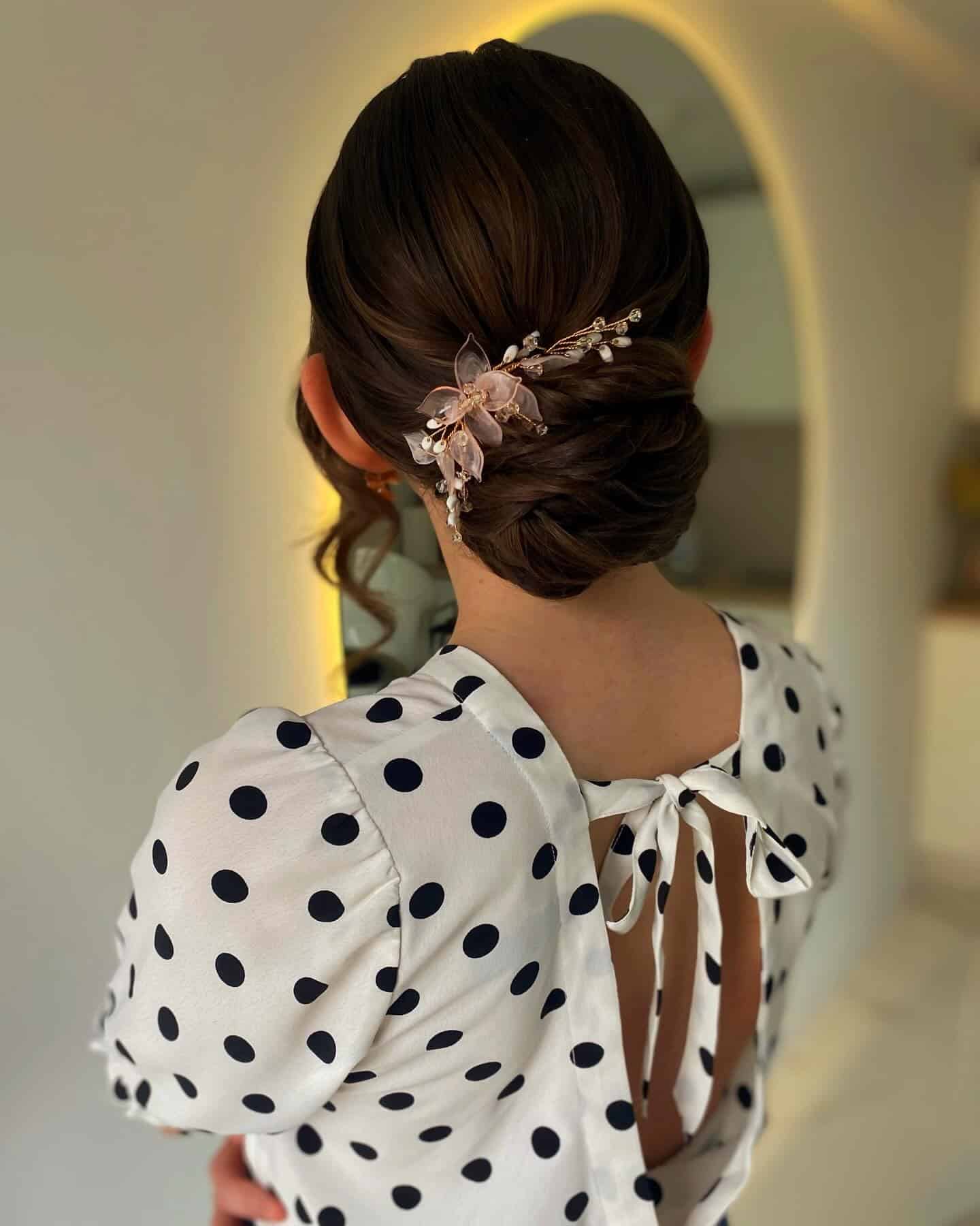 7. Chic Brunette Low Bun with Floral Crystal Pin - Wedding Hairstyles