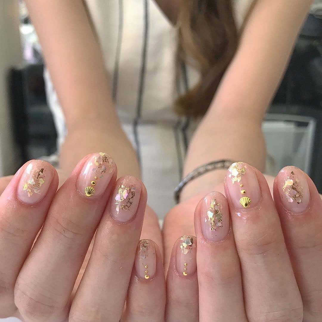 10. Gold-Dusted Shell Charm - shell nail ideas