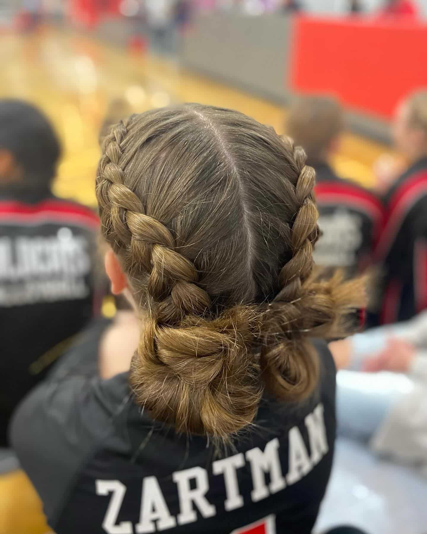 8. Double Dutch Braids into Twisted Buns on Light Brown Hair - Volleyball Hairstyles