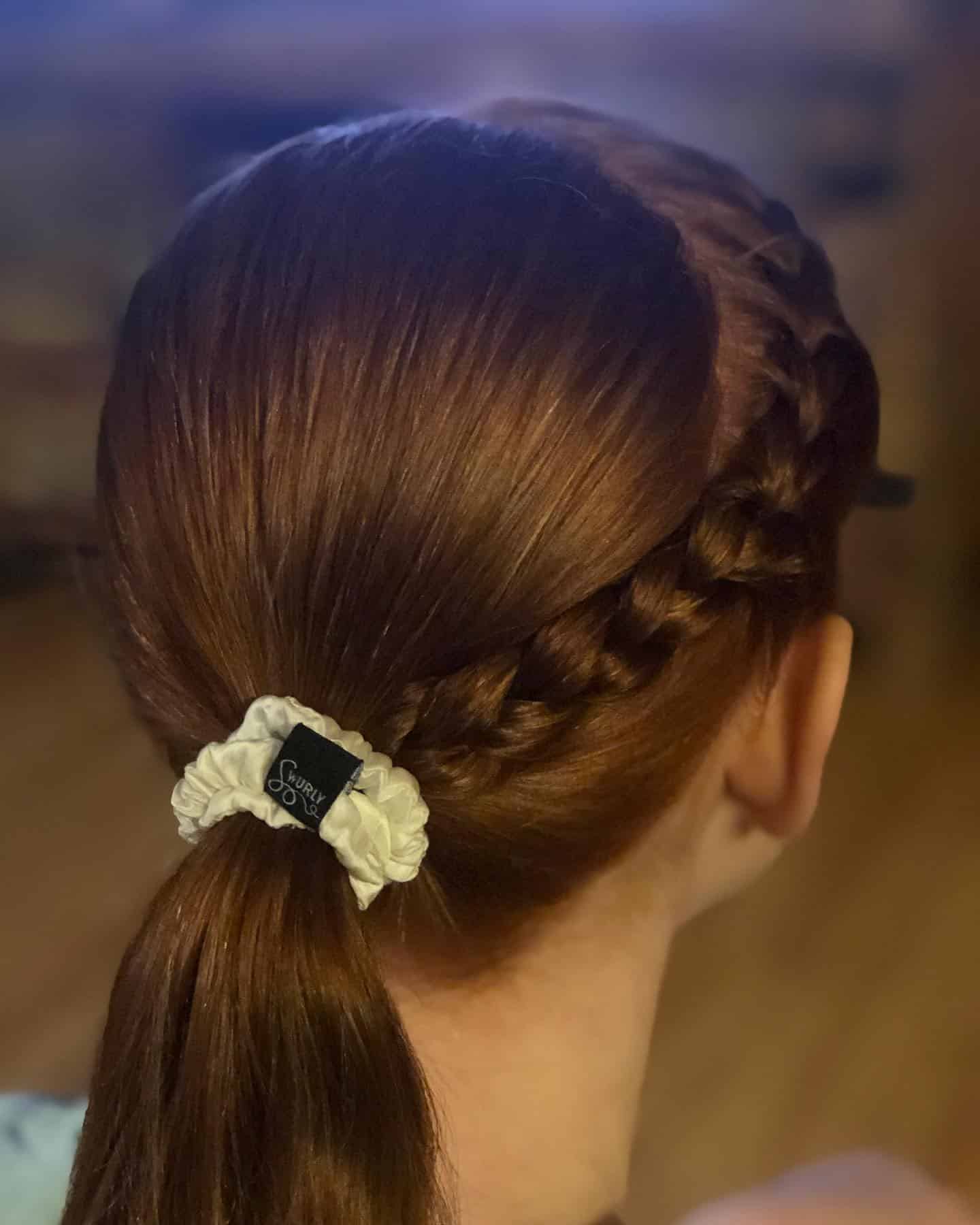 11. Side Dutch Braids into Low Ponytail on Auburn Hair - Volleyball Hairstyles