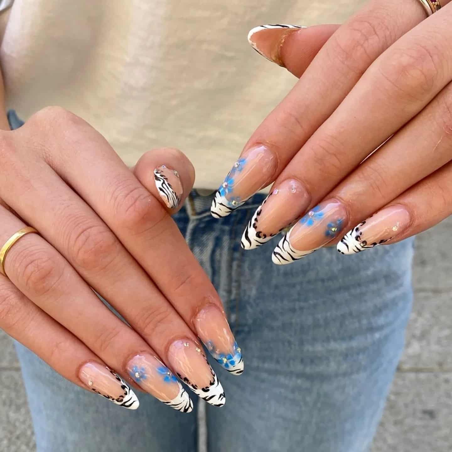 3. Zebra French Tips with Blue Floral Accents - zebra nail ideas