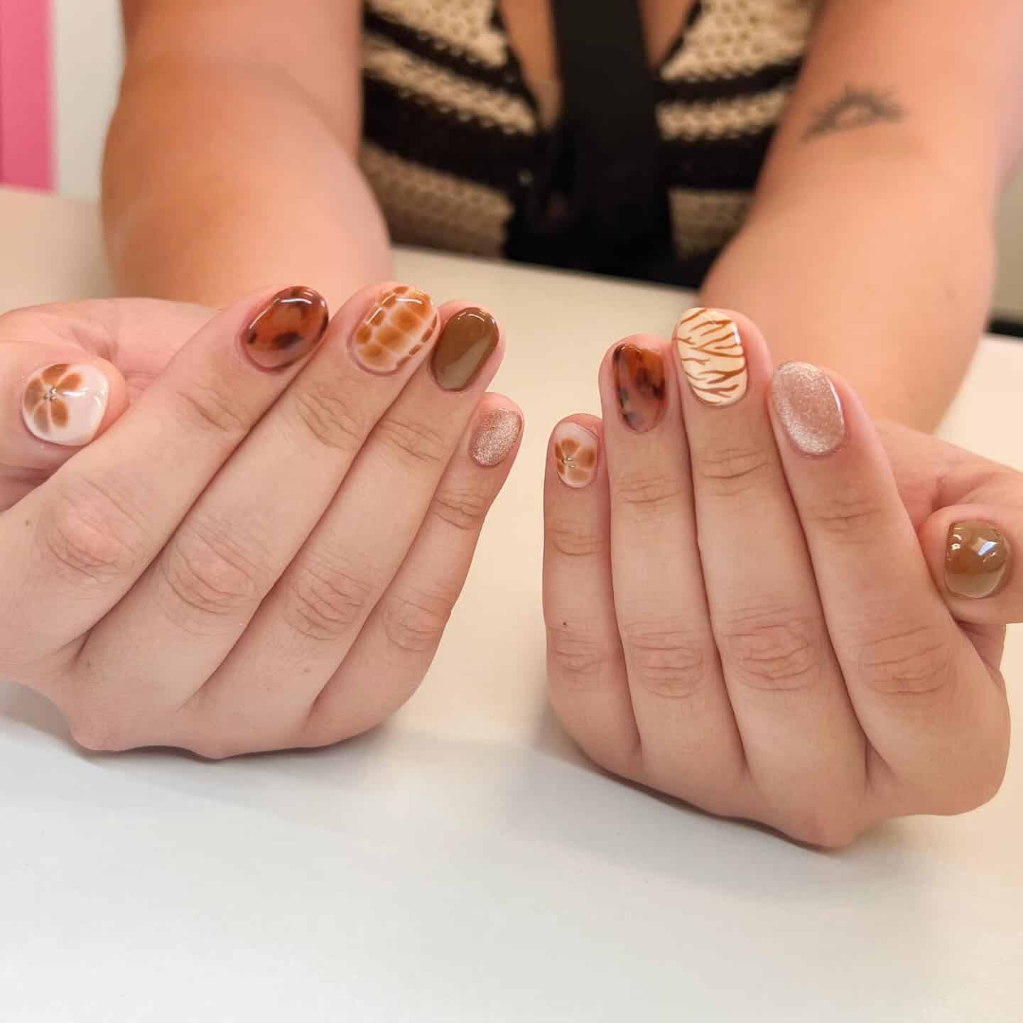 11. Mixed Earth Tones with Zebra Accent - zebra nail ideas