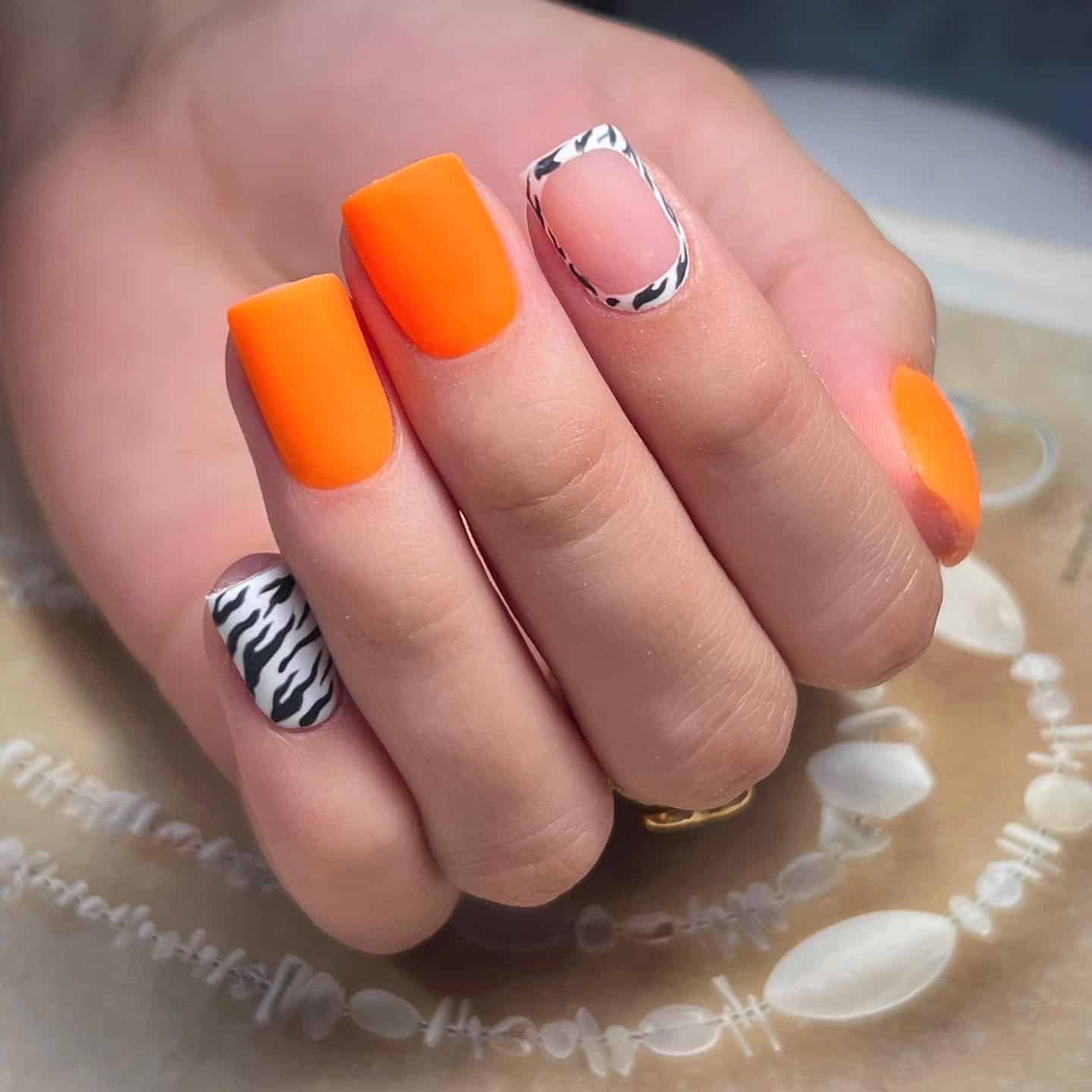 15. Neon Orange with Zebra Contrast - zebra nail ideas