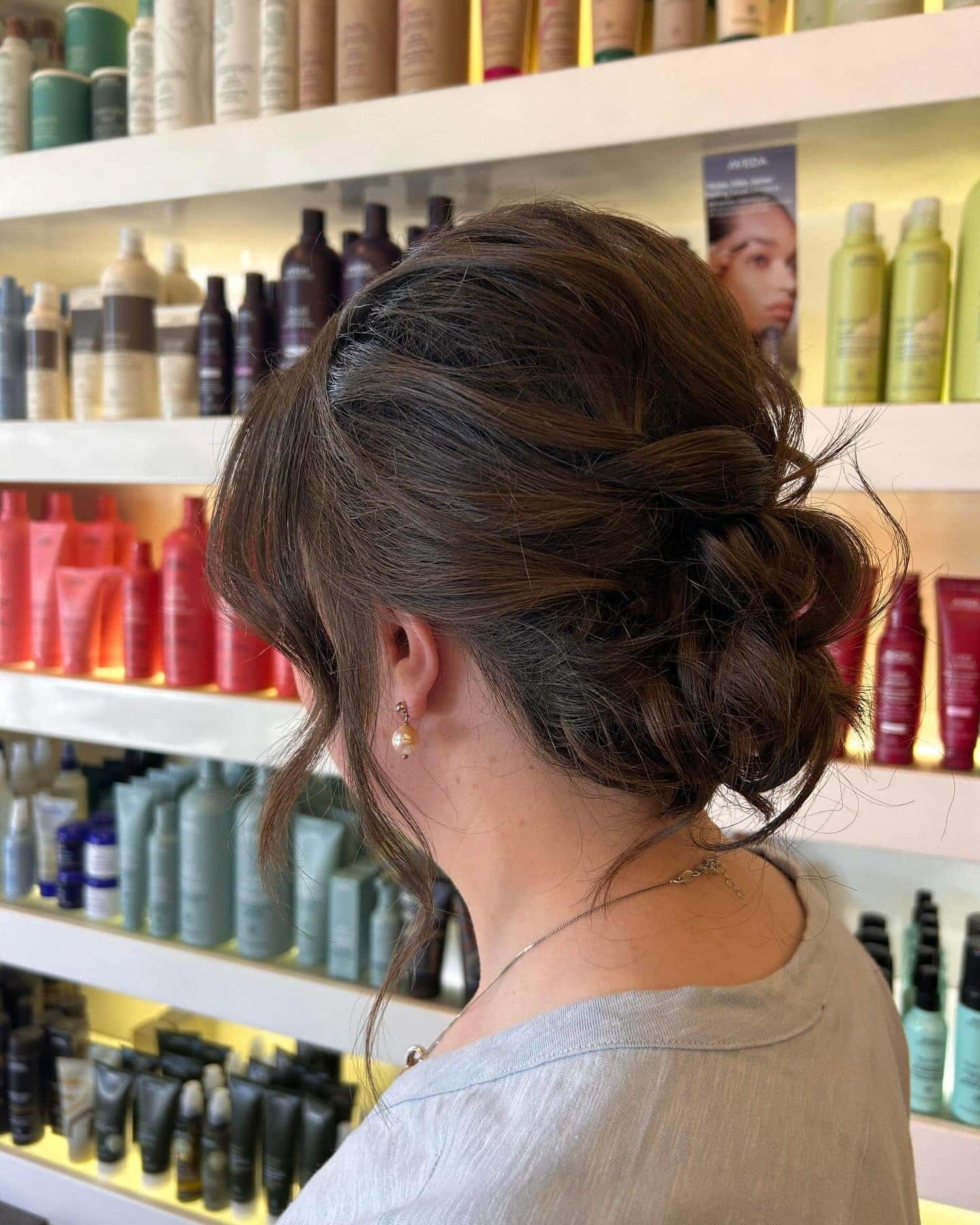 17. Romantic Low Bun with Loose Strands on Chestnut Brown - Formal Hairstyles