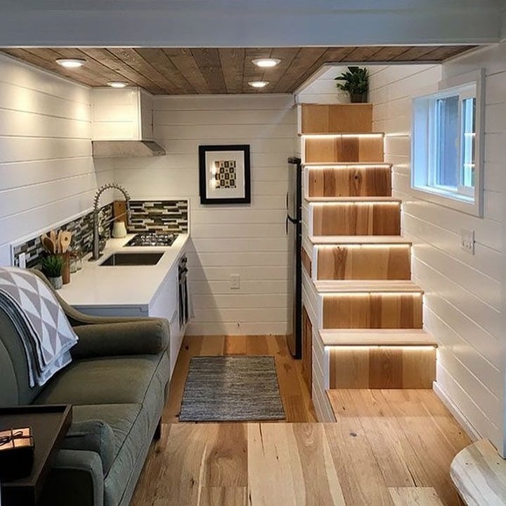 12. Compact White Interior with Illuminated Steps - tiny house living room ideas