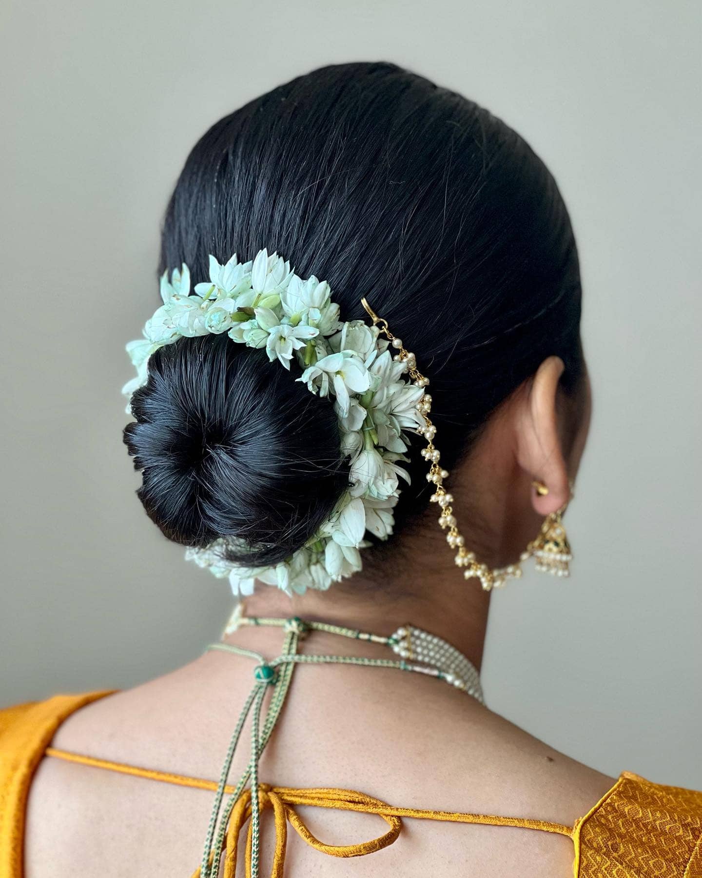 6. Classic Sleek Bun with White Jasmine Garland - Bun Hairstyles