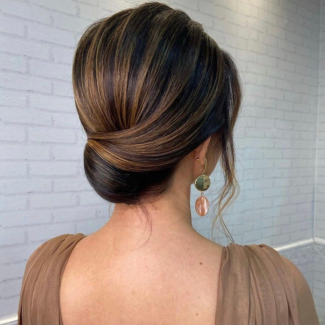 19. Smooth French Roll Bun on Dark Hair with Golden Highlights - Bun Hairstyles