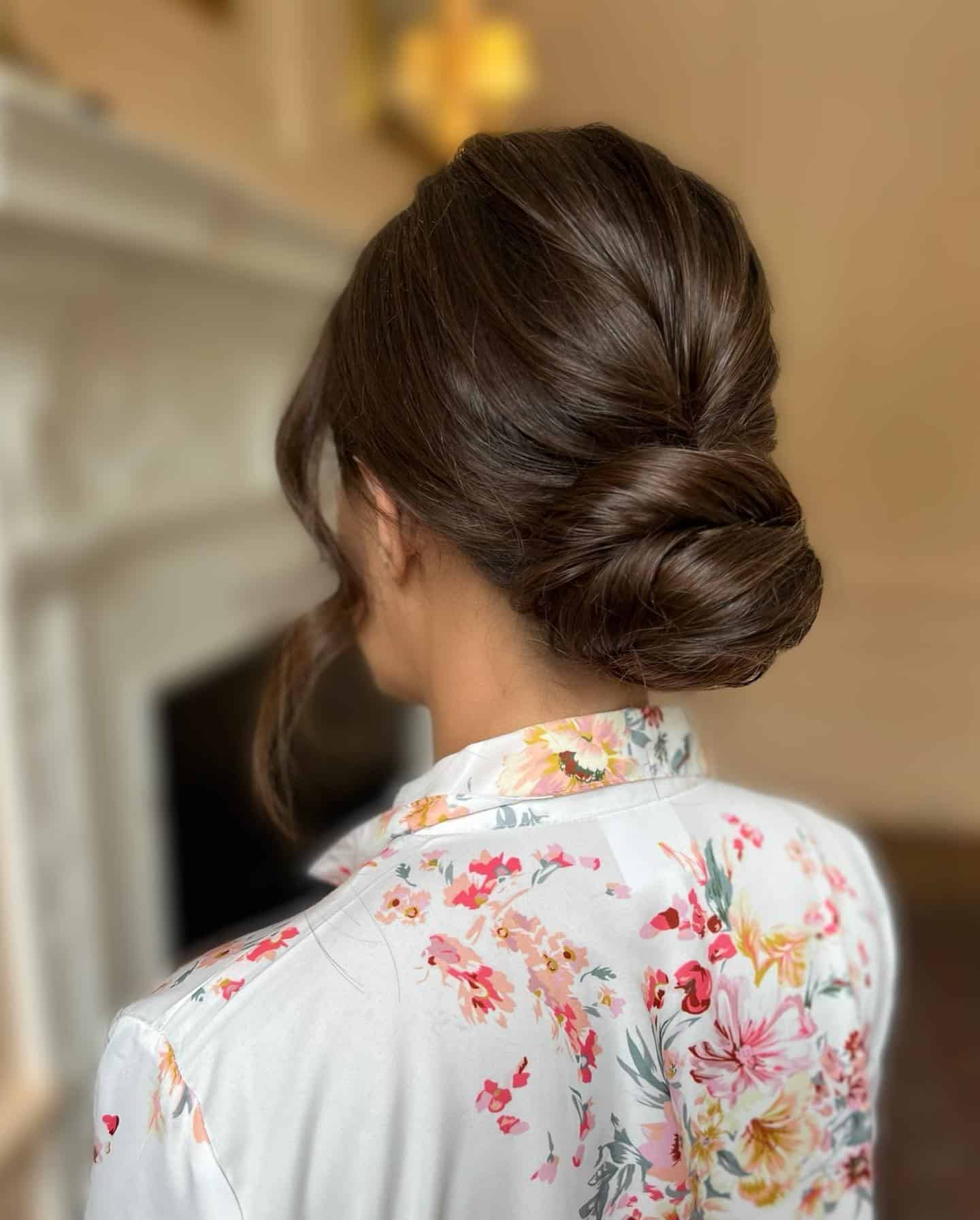 22. Polished Twisted Low Bun on Deep Brunette Hair - Bun Hairstyles