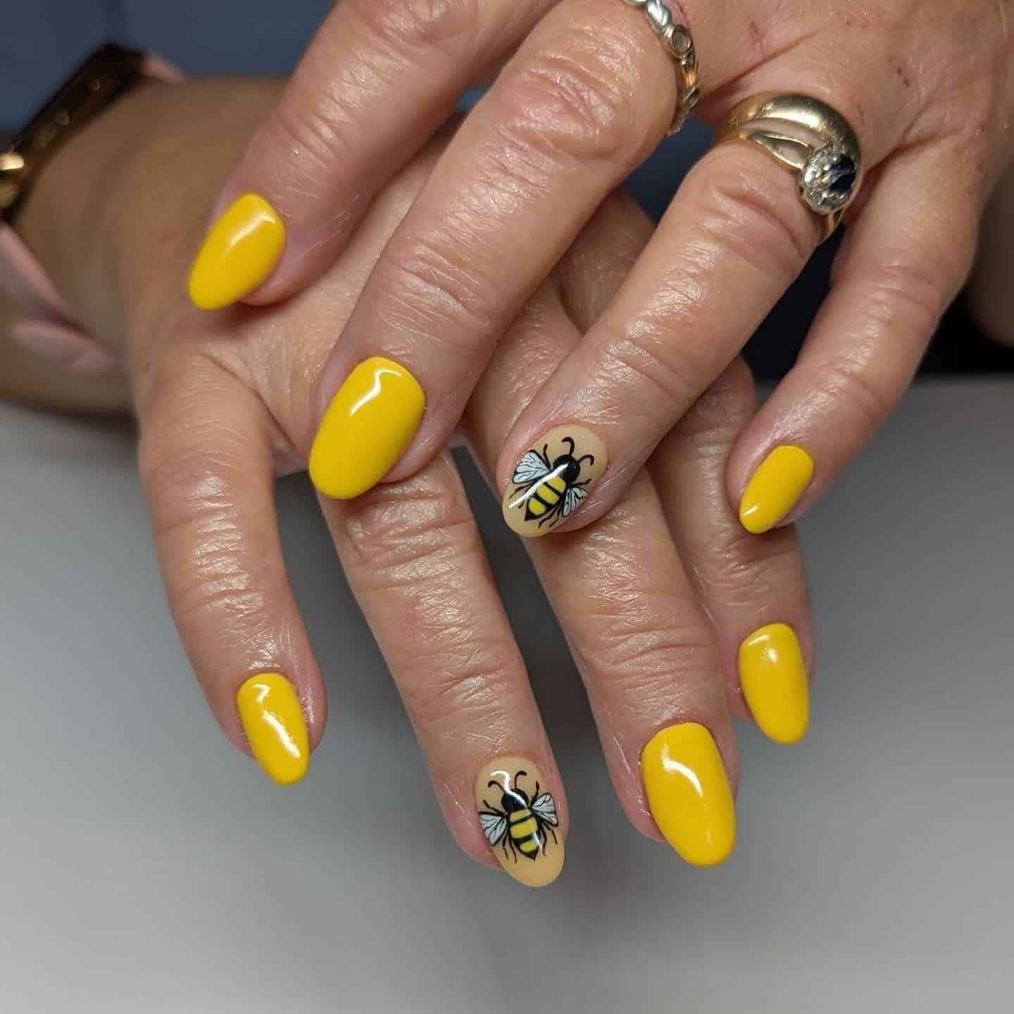 3. Bold Yellow Nails with Statement Bee Art - bee nail ideas