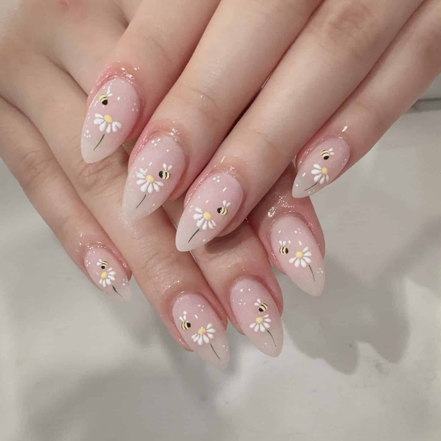 22. Soft Nude Daisy and Bee Almond Nails - bee nail ideas