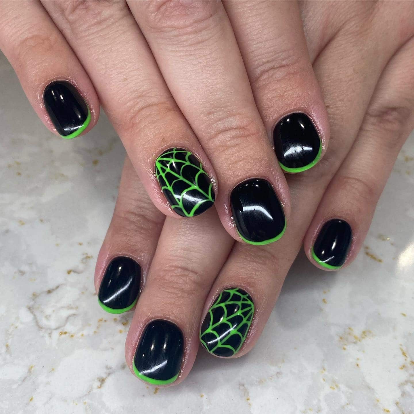 3. Webbed Accents on Short Rounds - black and green nail ideas