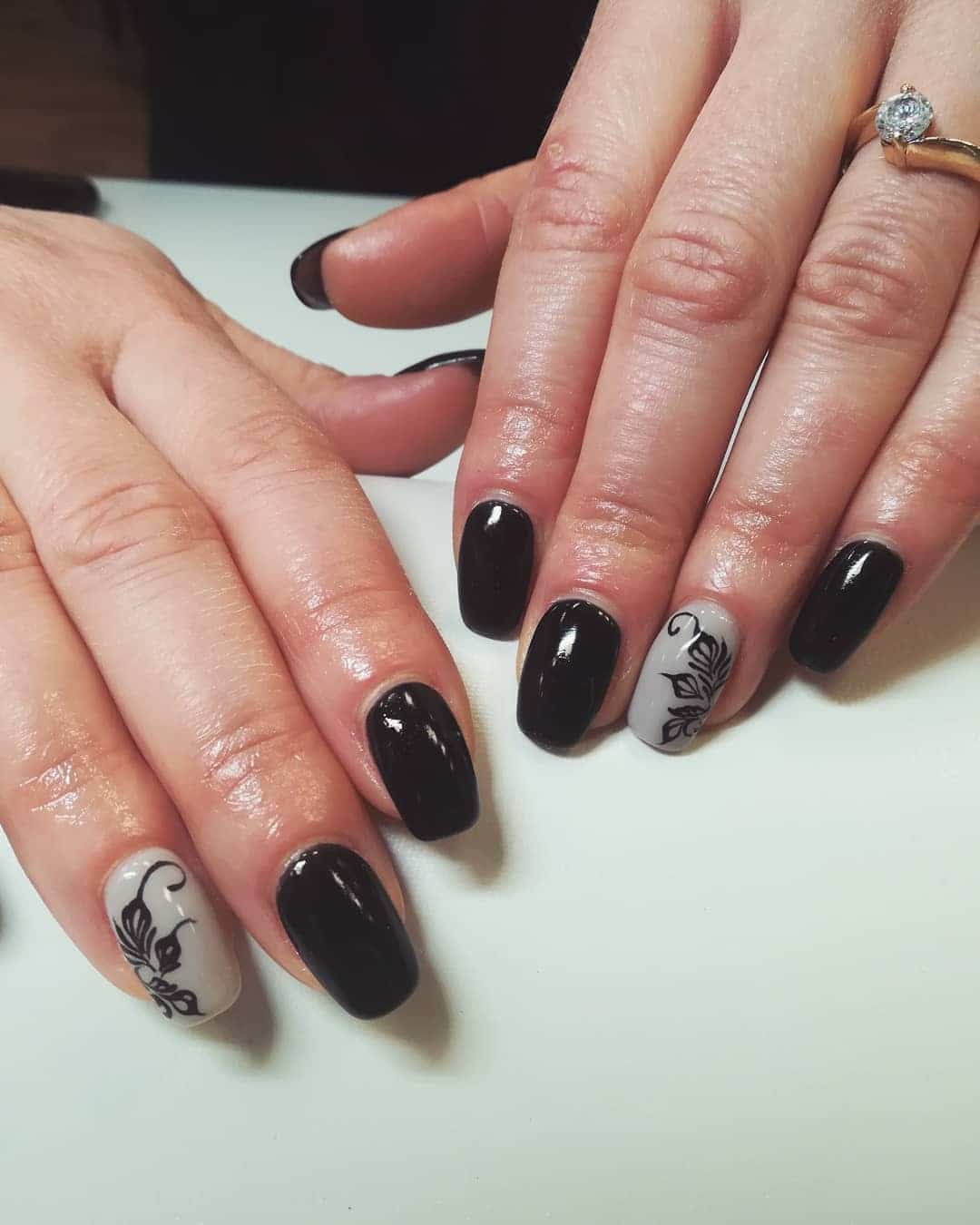 15. Glossy Black with Grey Floral Accent - black and grey nail ideas