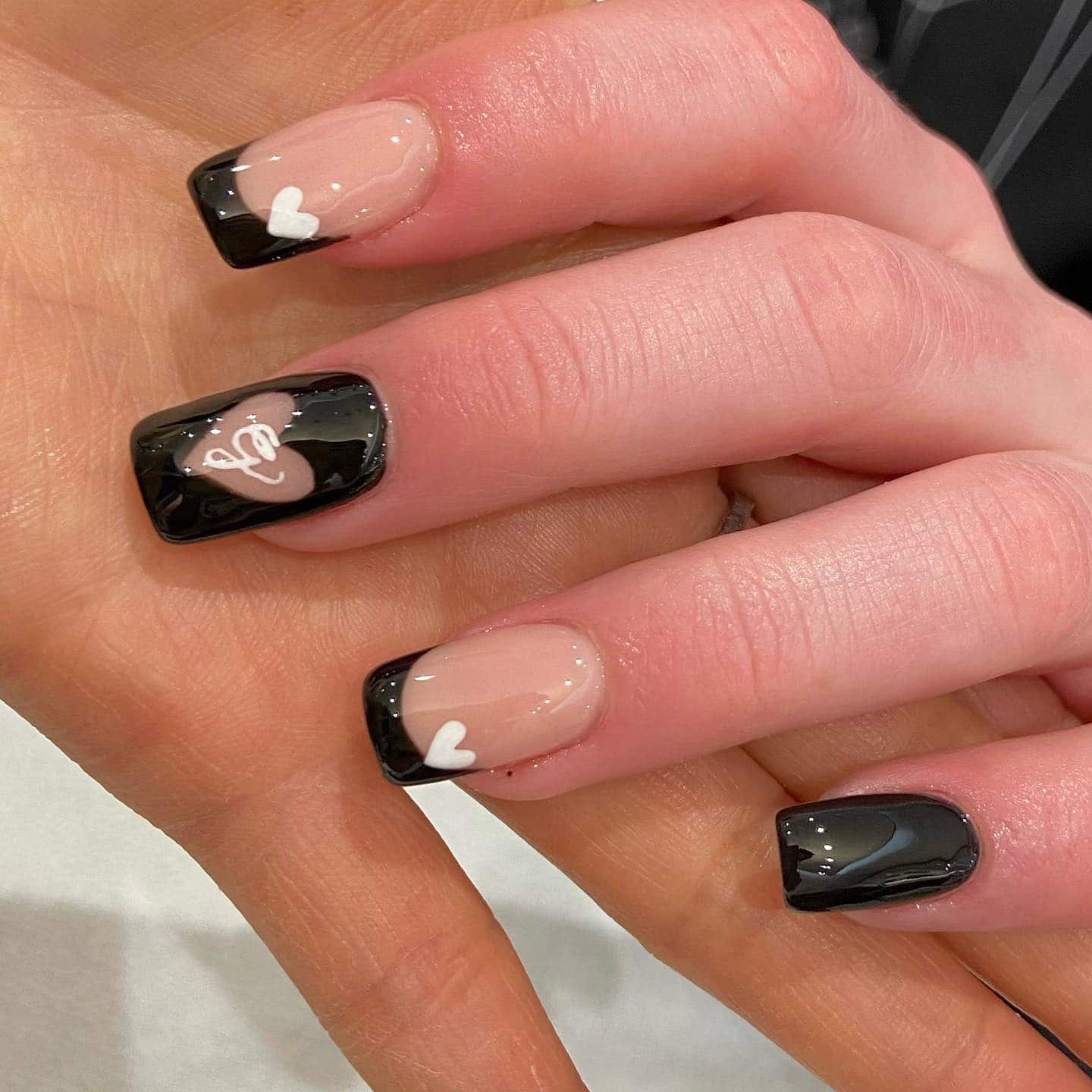 20. Black French with White Heart Accents - black valentine nail ideas