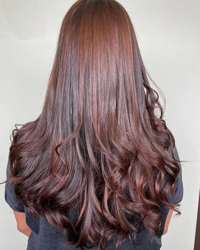 3. Glossy Mahogany Curls - Warm Brown Hair Color