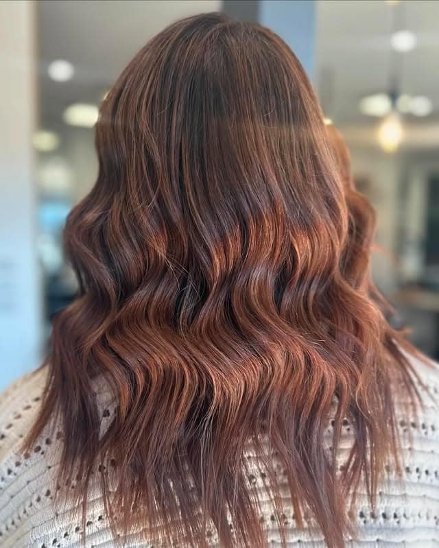 11. Copper-Infused Waves - Warm Brown Hair Color
