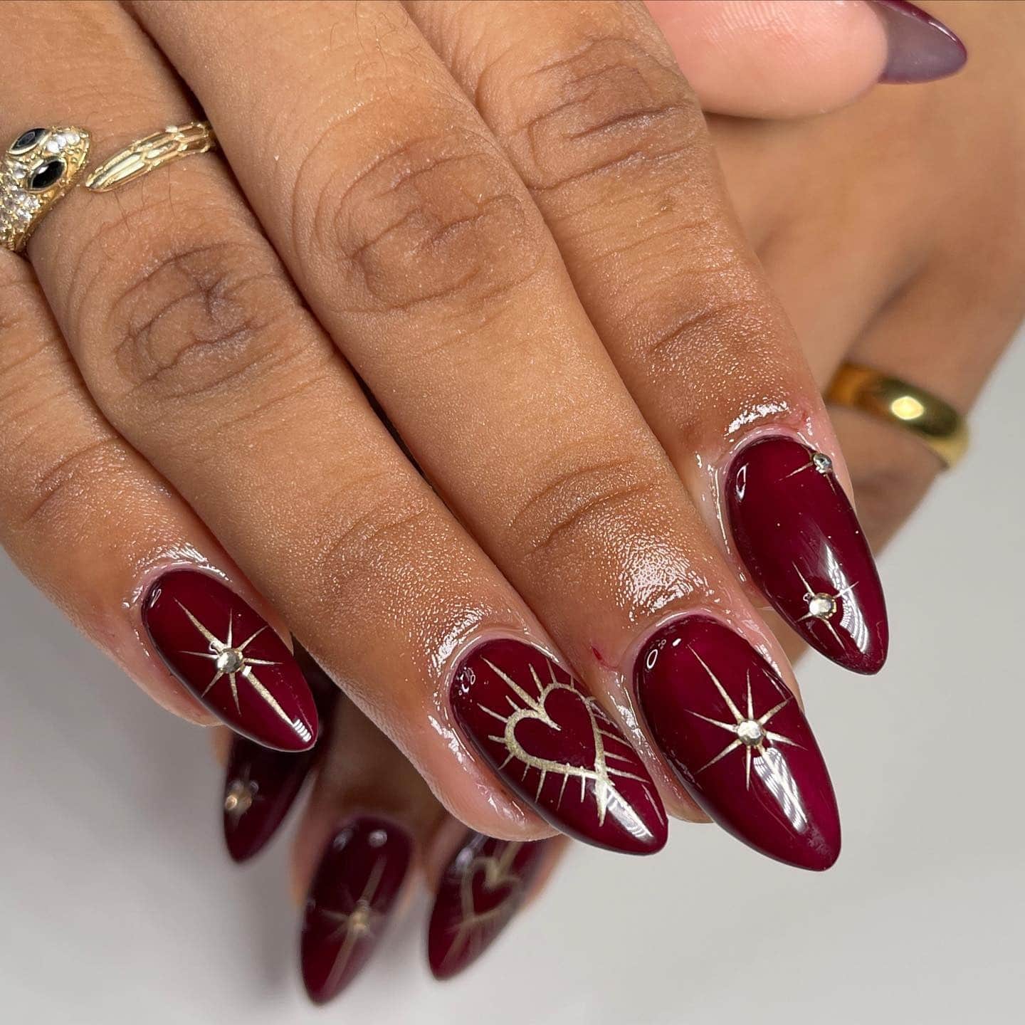 6. Burgundy Almond Nails with Celestial Gold Art - burgundy and gold nail ideas