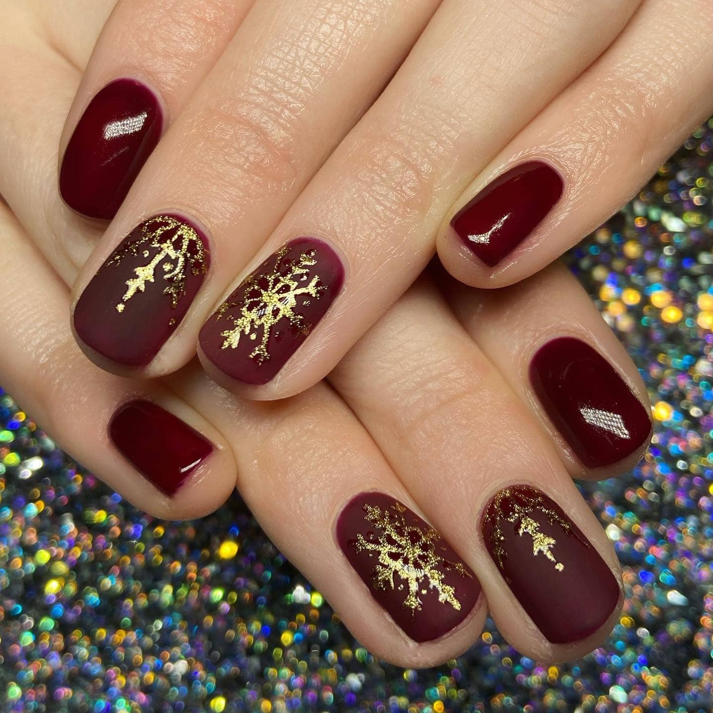 9. Burgundy Nails with Gold Snowflake Design - burgundy and gold nail ideas