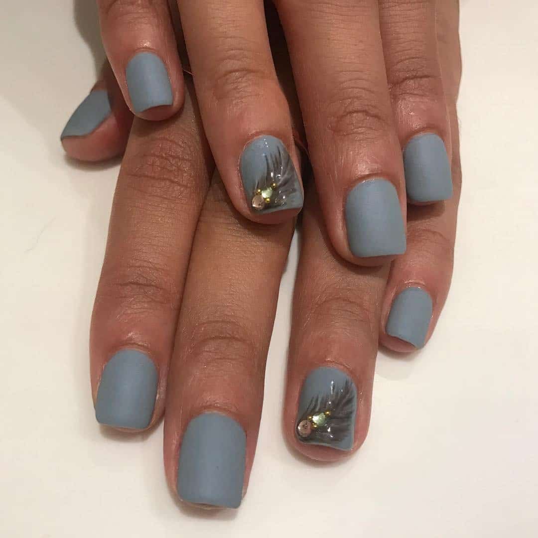 11. Matte Blue Feather Accent Nails - feather nail ideas