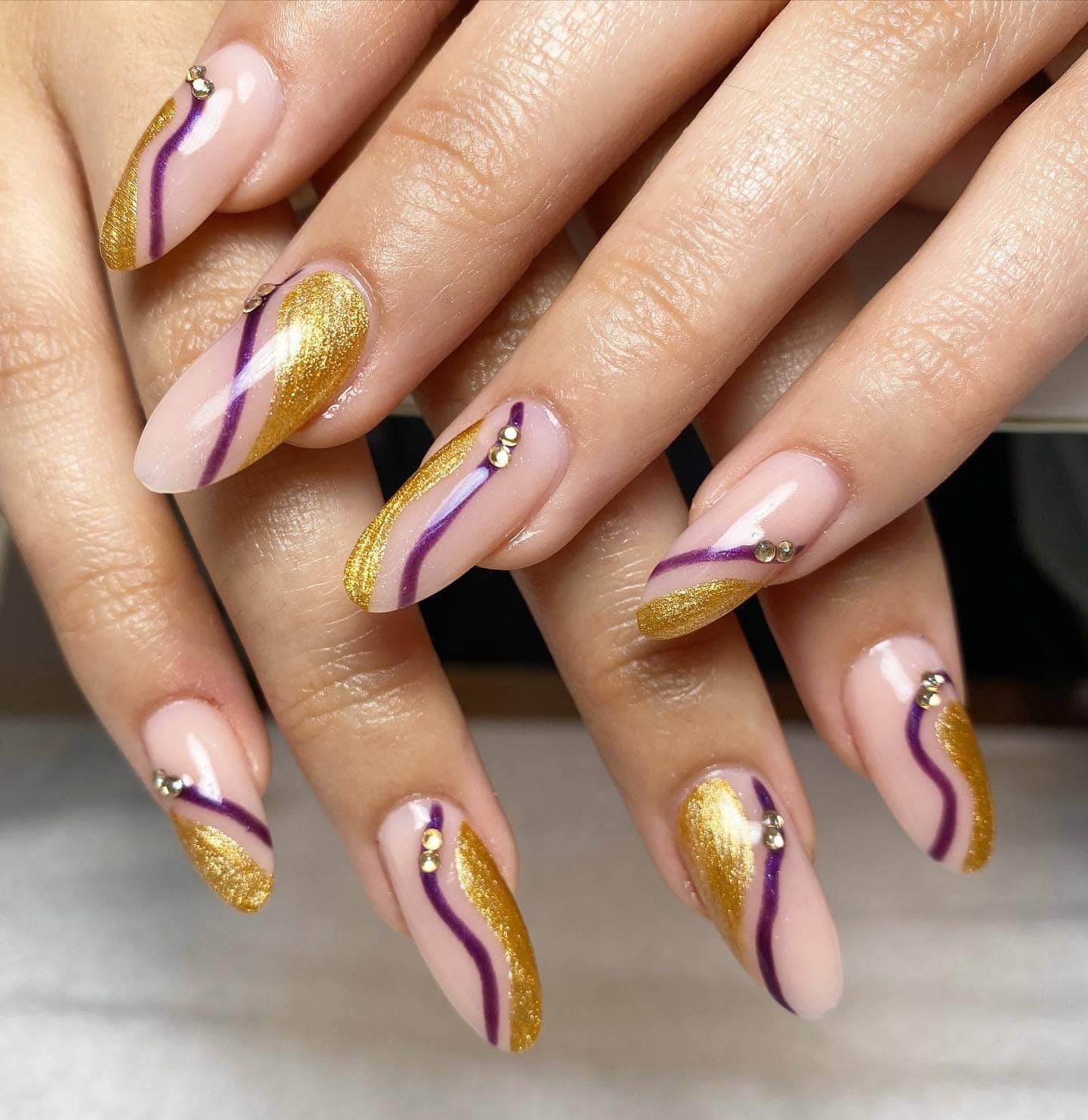 17. Golden Waves on Mauve Canvas - gold and purple nail ideas