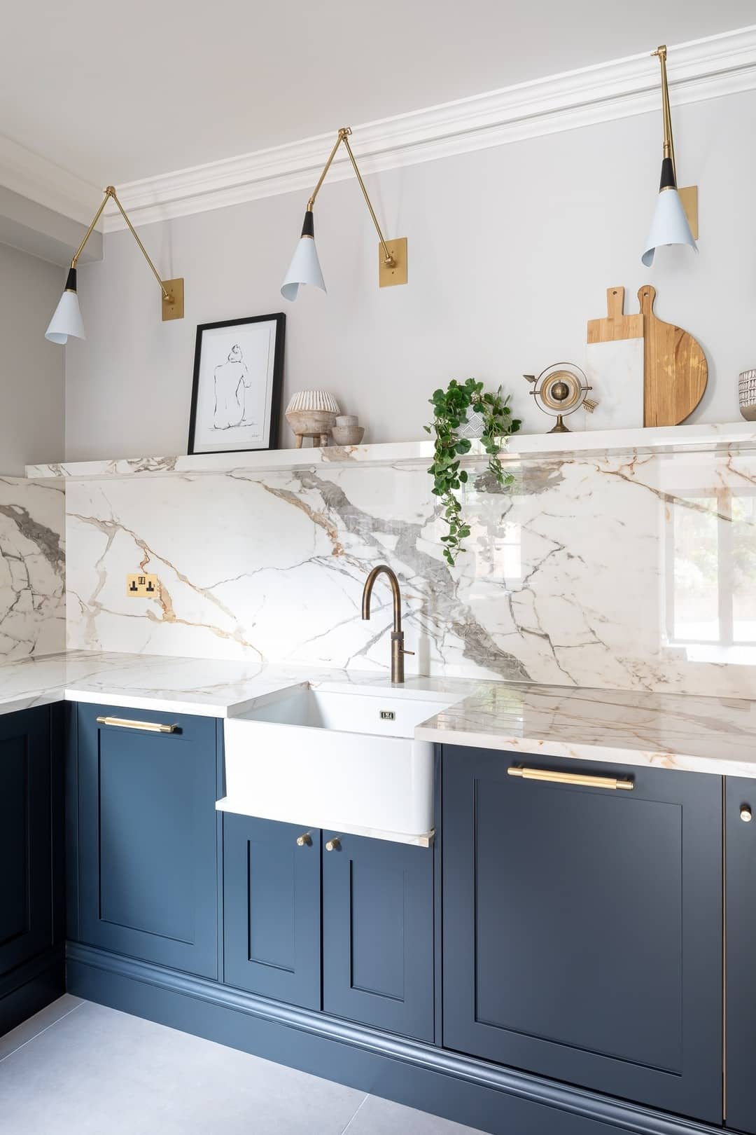 5. Classic Marble Sophistication with Navy Cabinets - kitchen lighting ideas