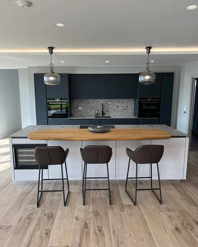 11. Sleek Contrast with Charcoal Blue and Oak Accents - dark blue kitchen ideas