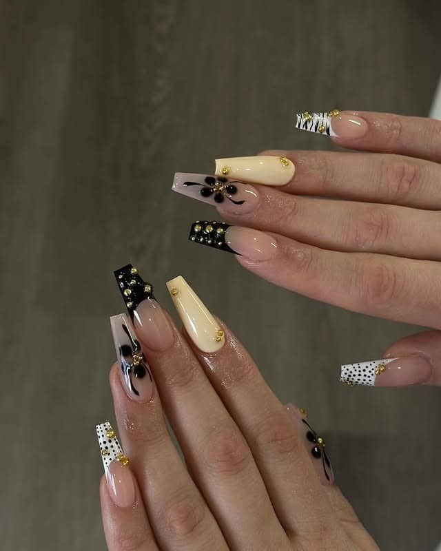 22. Black and Nude Art with Gold Accents - long coffin nail ideas