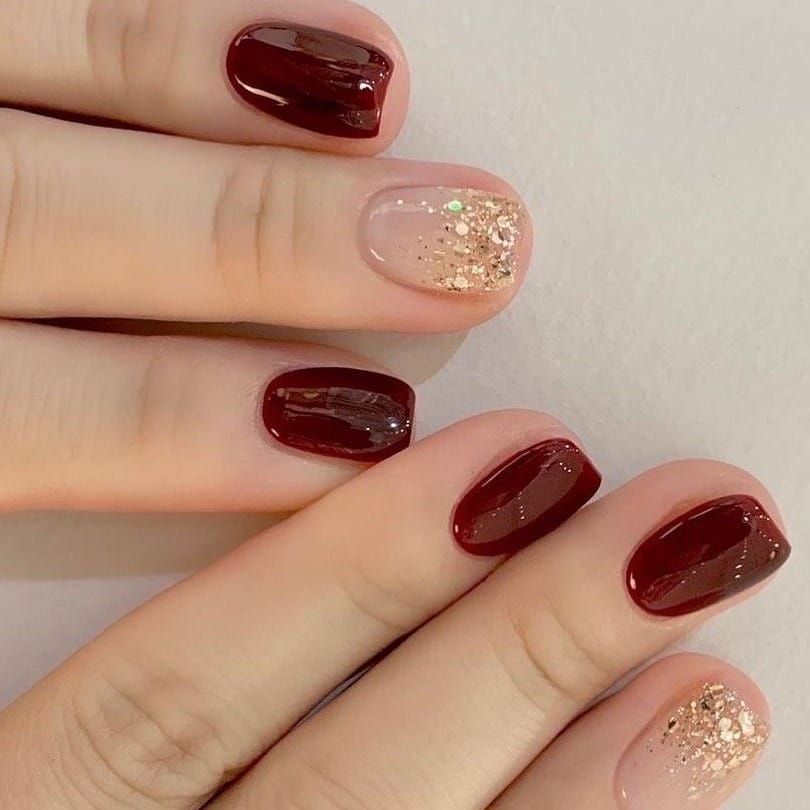 7. Classic Wine with Gold Dust - maroon and gold nail ideas