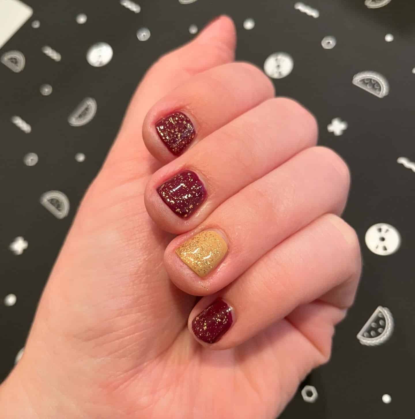 9. Subtle Gold Accent Shorties - maroon and gold nail ideas