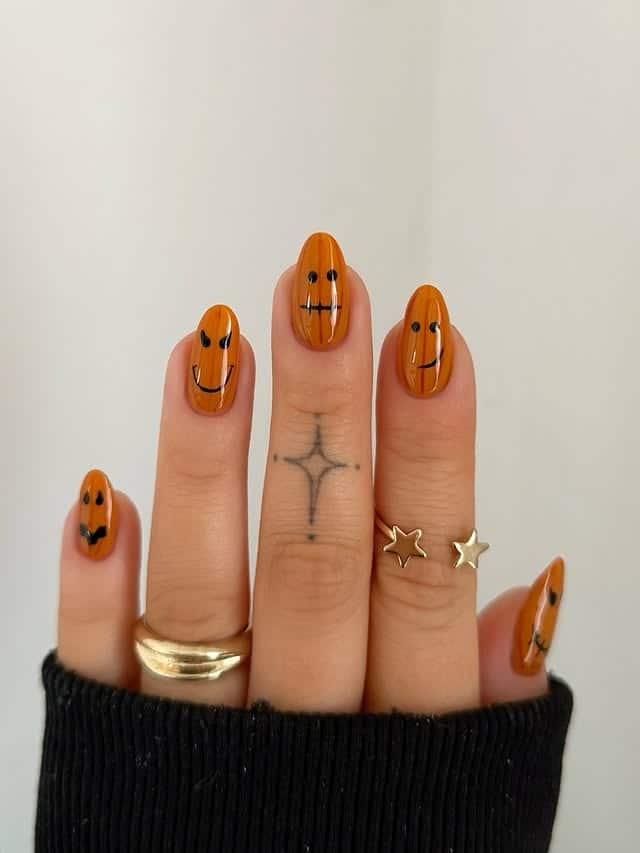 21. Smiling Pumpkin Tips - orange and black nail ideas
