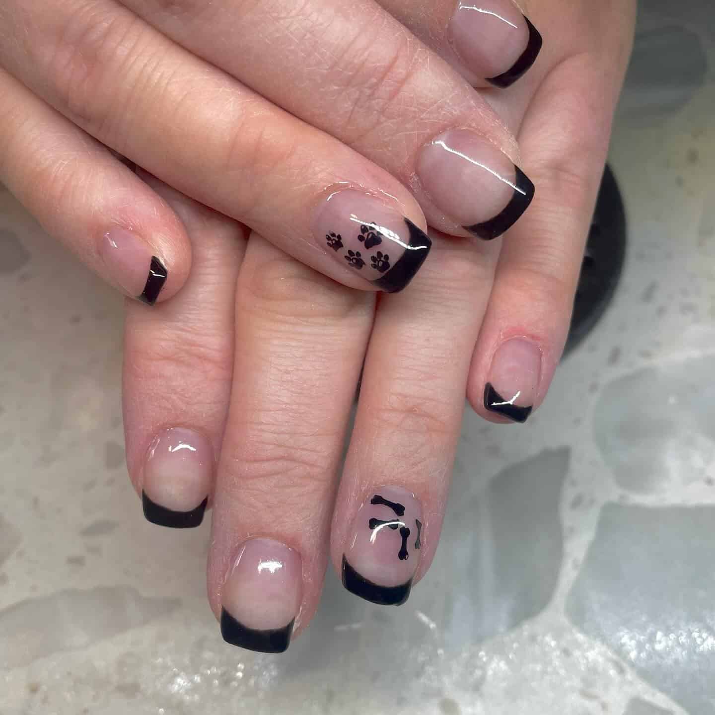 10. Black French with Bone and Paw Details - paw print nail ideas