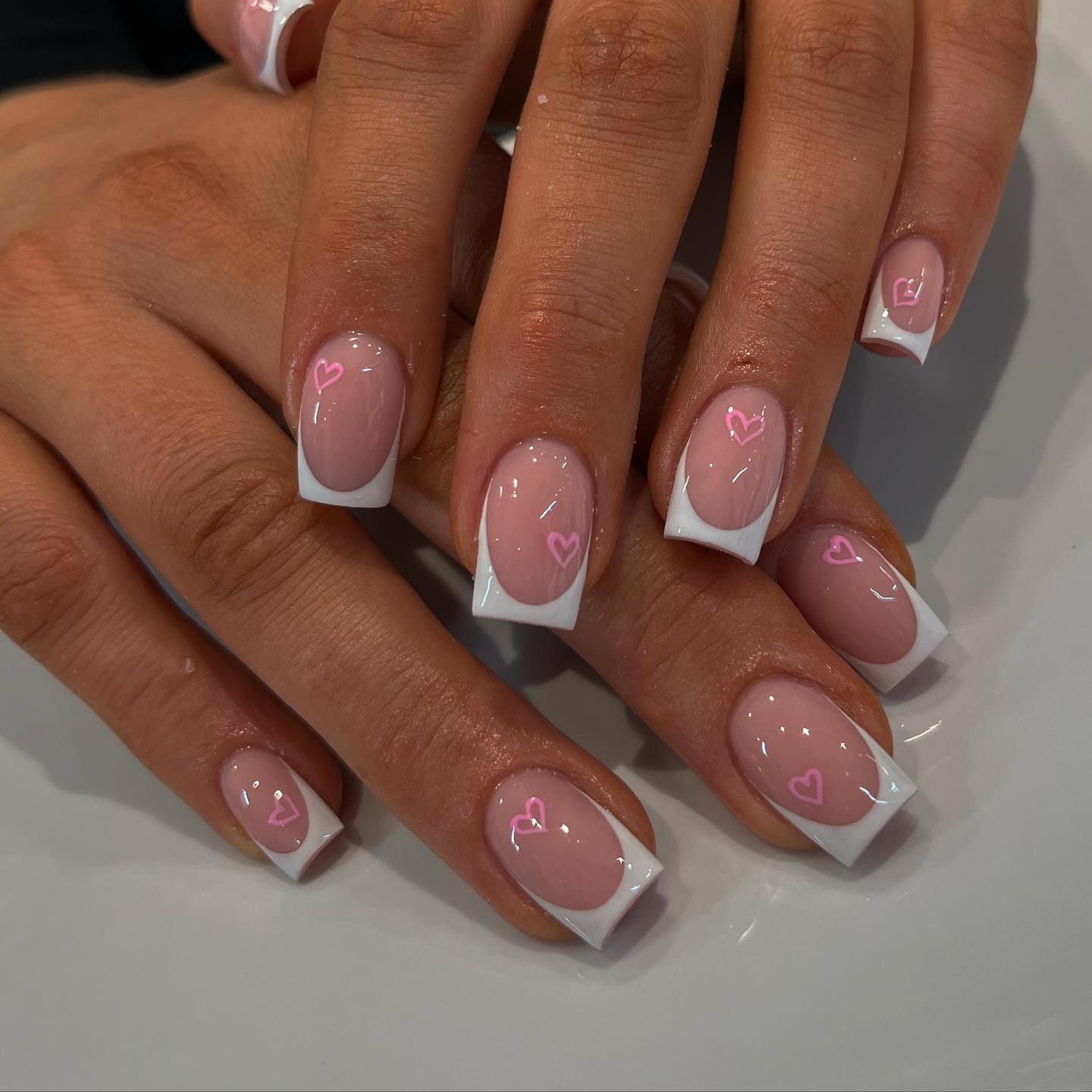 18. French Tip Nails with Pink Heart Accents - pink valentine nail ideas