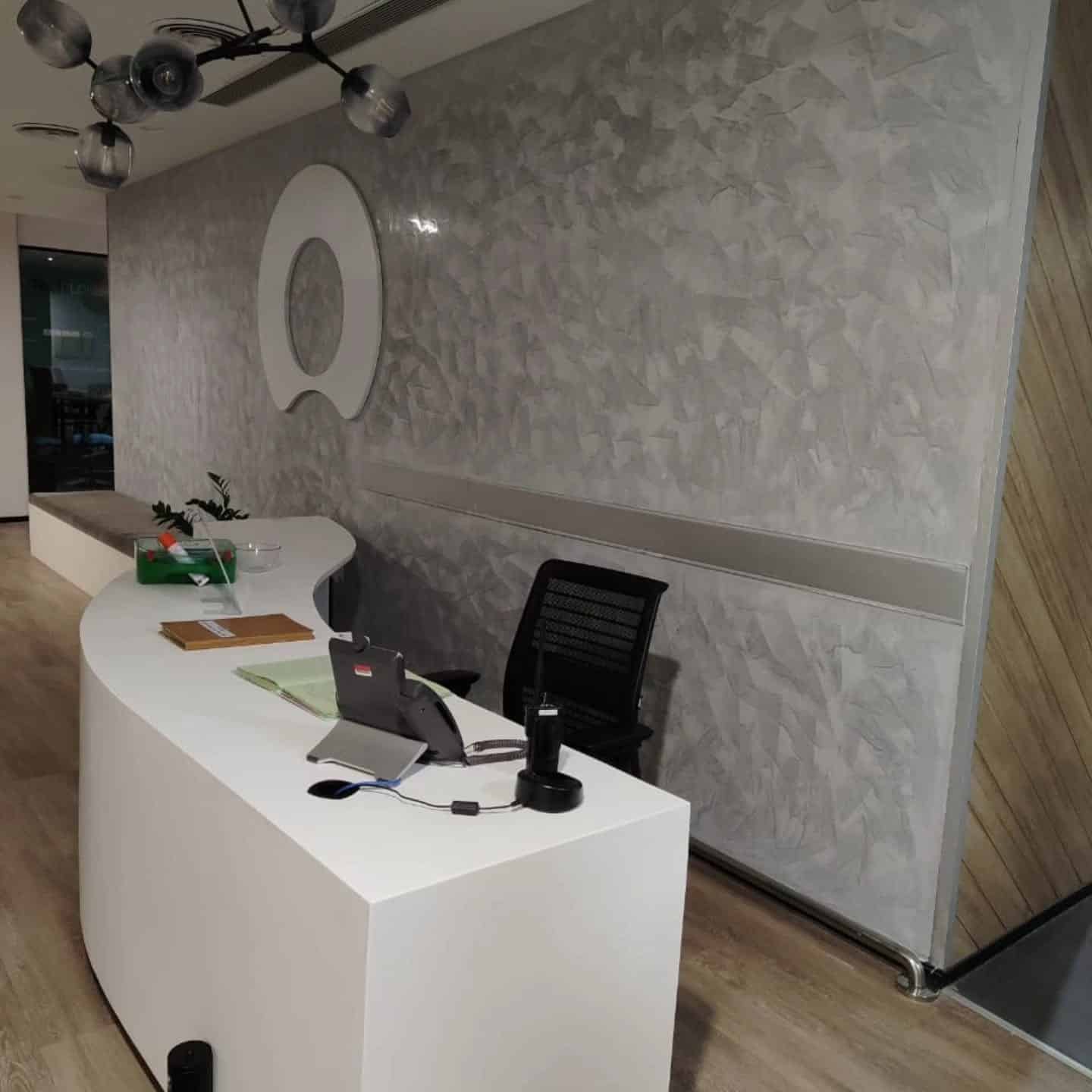 13. Modern Reception in Concrete Gray and Matte White - corporate office ideas