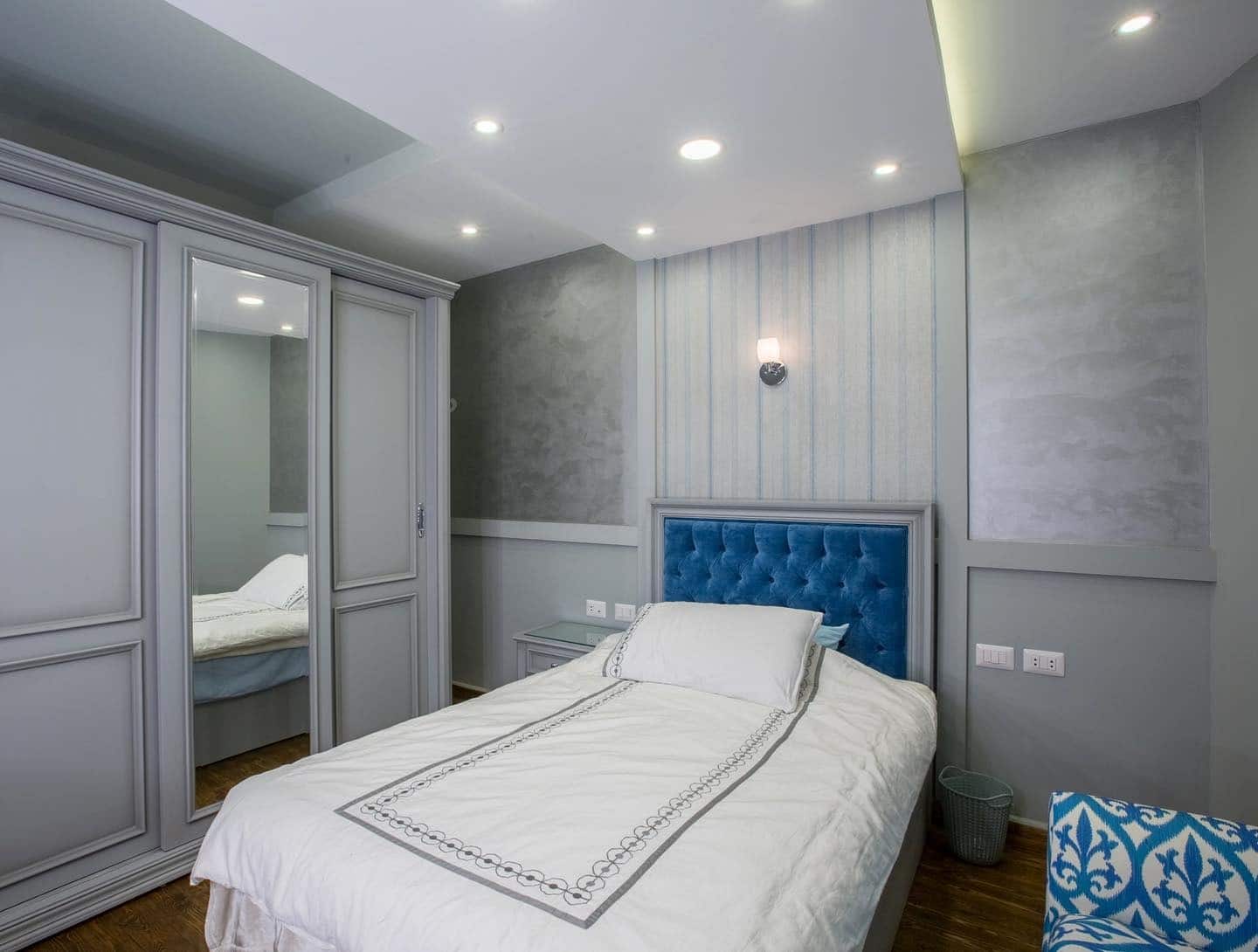 5. Parisian-Inspired Soft Gray with Velvet Blue Detail - gray and blue bedroom ideas