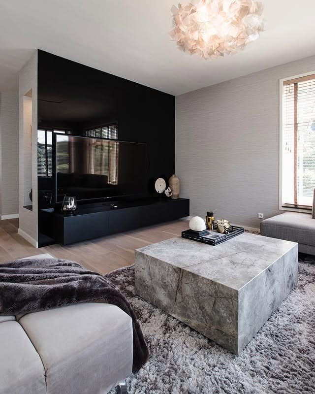 2. Sleek Monochrome Sophistication with Stone Texture - large living room wall ideas