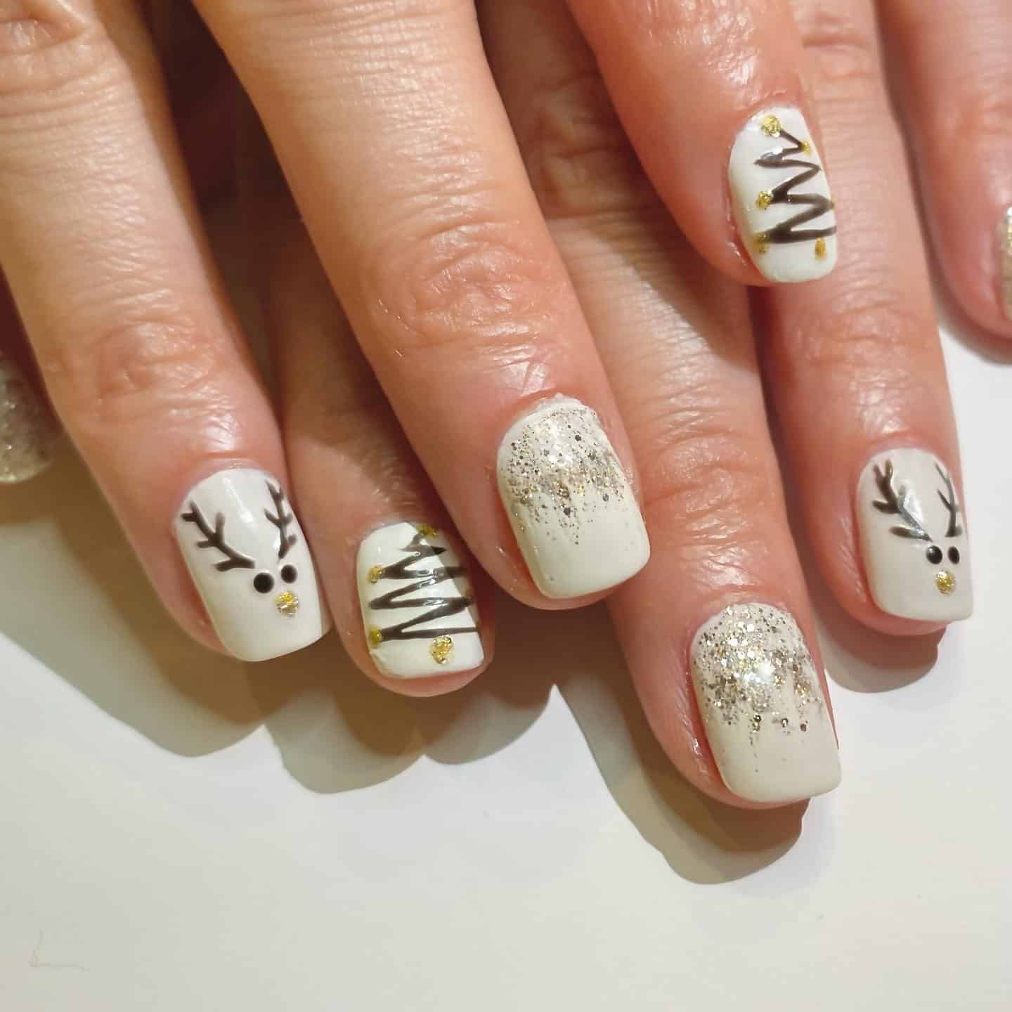 19. White & Gold Winter Reindeer - reindeer nail ideas