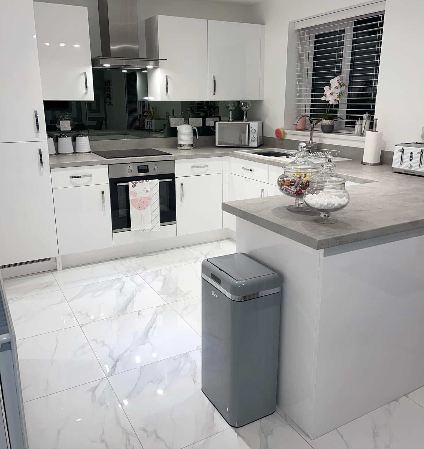 15. Polished Perfection with a Hint of Glamour - white kitchen floor ideas