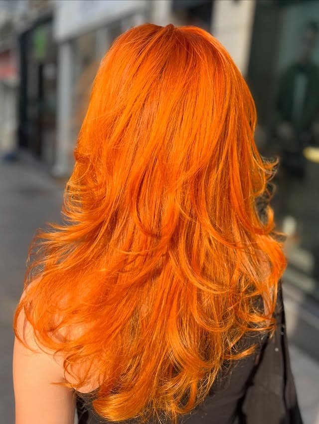 2. Layered Neon Tangerine Waves - Orange Hair Color