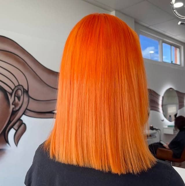 17. Straight Citrus-Orange Mid-Length Cut - Orange Hair Color