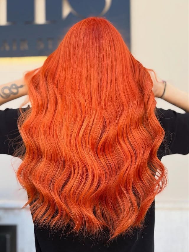 20. Long Radiant Orange Glam Waves - Orange Hair Color