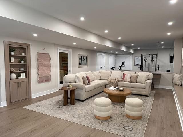 6. Expansive Lounge with Cushioned Neutral Sectional - basement living room ideas