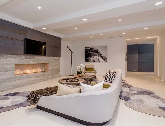 7. Contemporary Basement with Curved Seating and Linear Fireplace - basement living room ideas