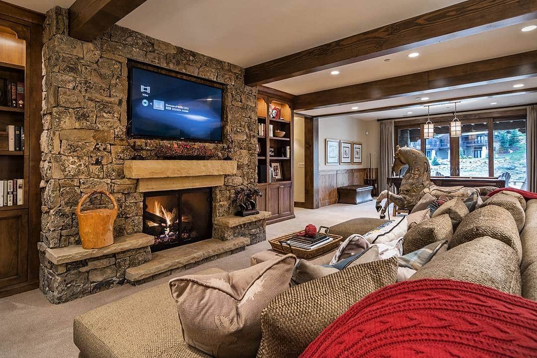 10. Rustic Stone Fireplace with Cozy Mountain-Lodge Style - basement living room ideas