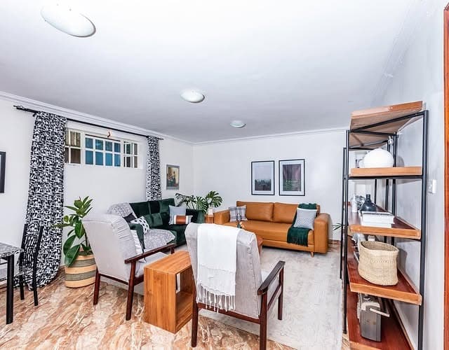 14. Eclectic Living Area with Mixed Seating and Warm Woods - basement living room ideas