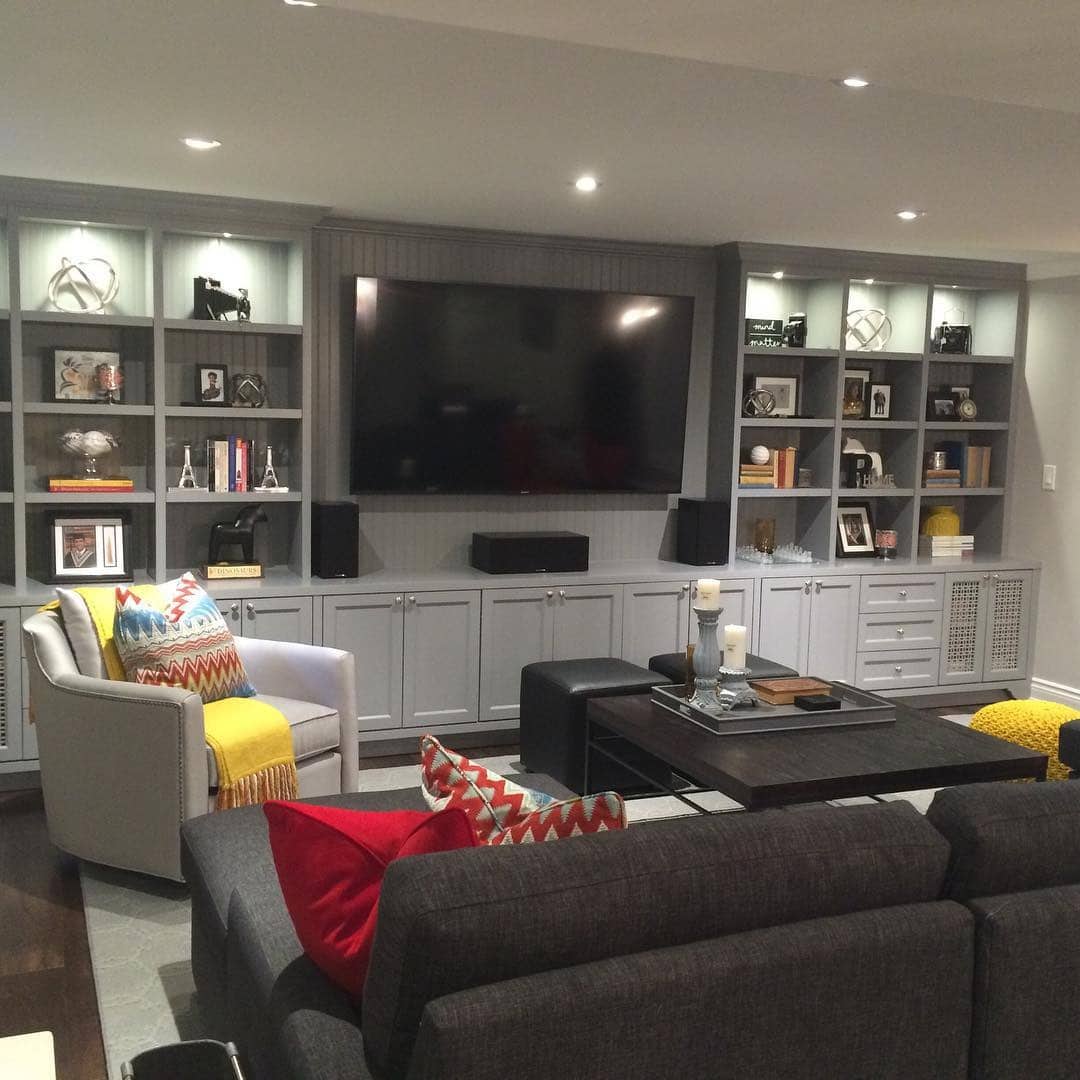 19. Color-Rich Entertainment Hub with Tailored Shelving - basement living room ideas