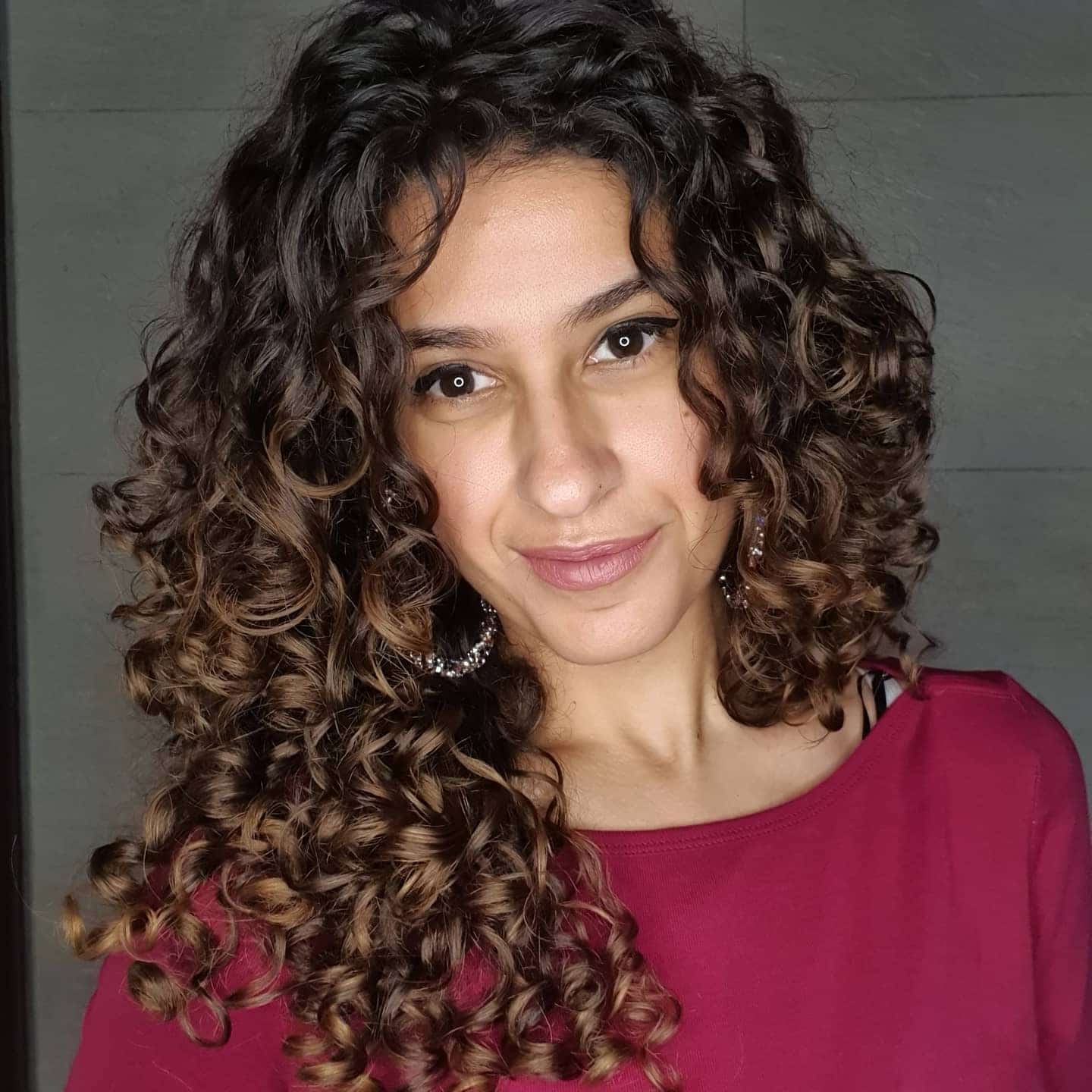 1. Defined Corkscrew Layers with Warm Brunette Tones - Layered Curly Hairstyles
