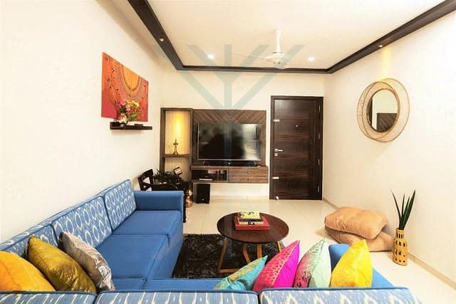 9. Bright Blue Corner Sofa with Colorful Cushions - indian style living room ideas