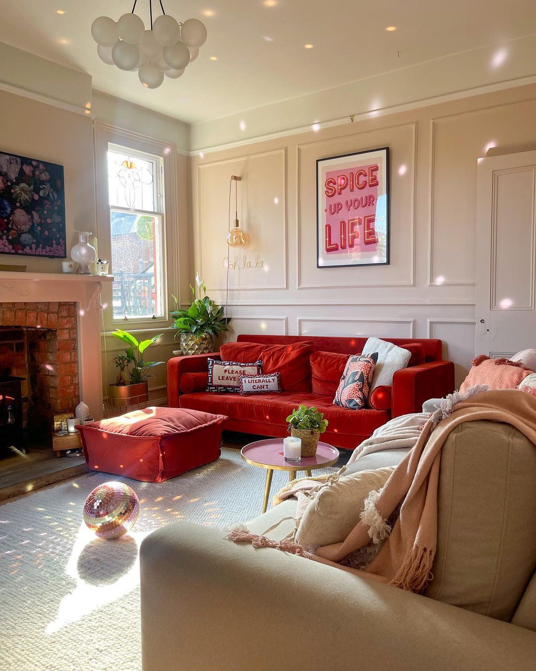12. Cream Paneling Paired with Bold Cherry Red Seating - paint ideas for living room